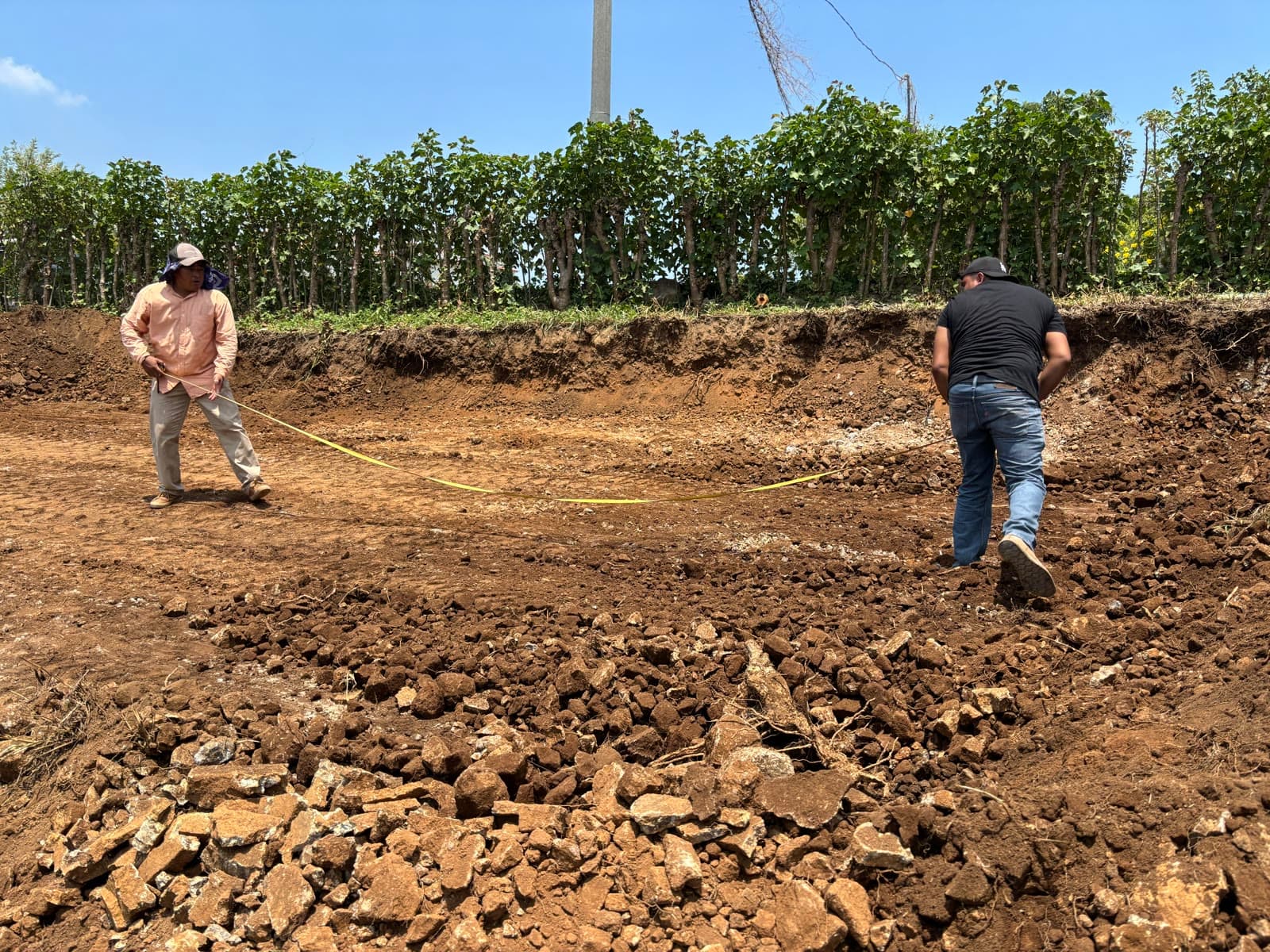 Two people measuring a cleared construction site in Guatemala