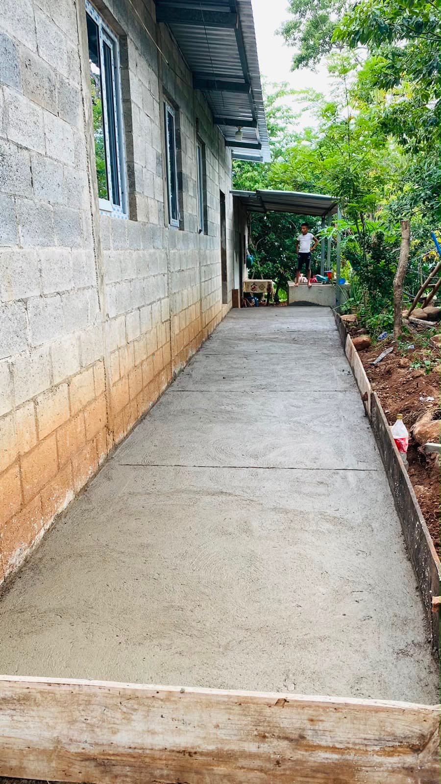Un niño al final de un camino de concreto recién construido